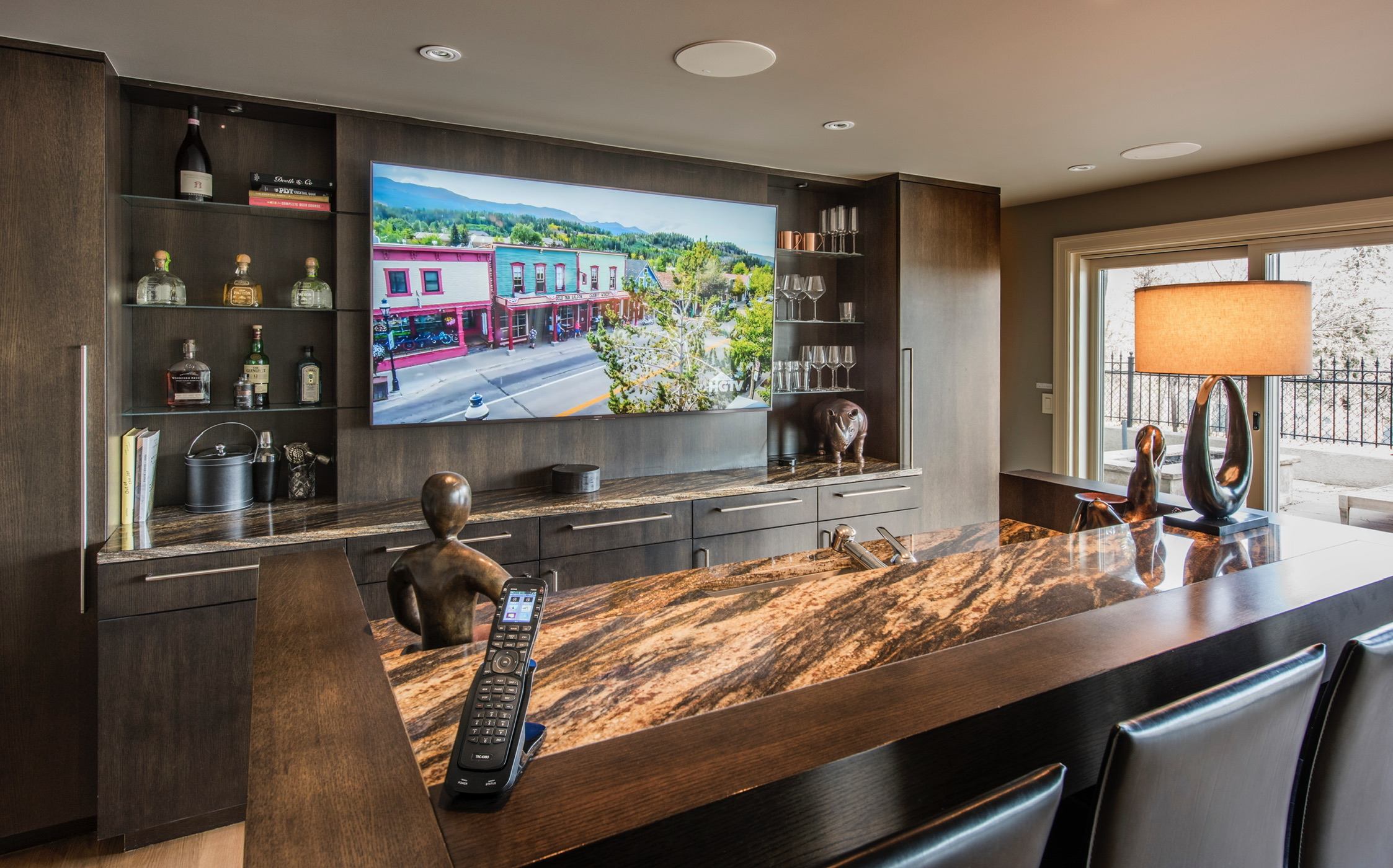 Finished basement bar with integrated TV, speakers, and lighting